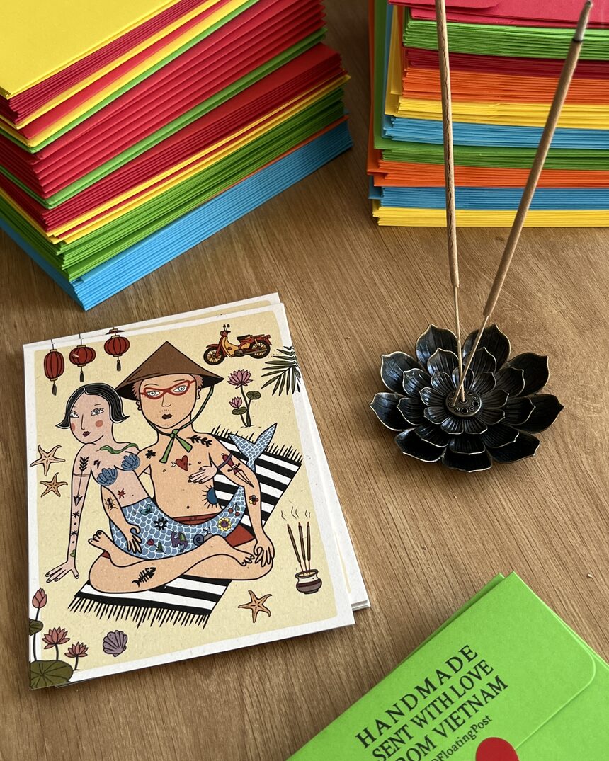 Rainbow stacks of handmade Floating Post envelopes with a hand-drawn mermaid card and incense in Hội An
